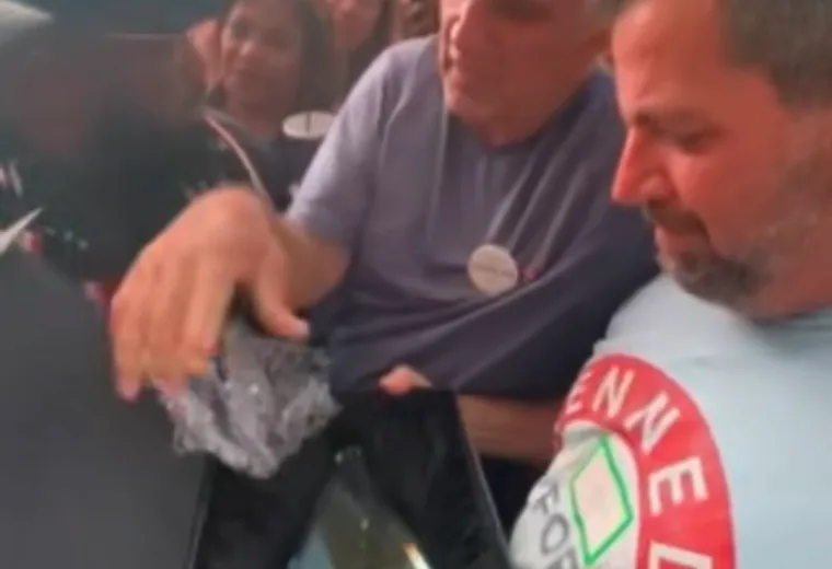 Two men examining a printed shirt at a public gathering