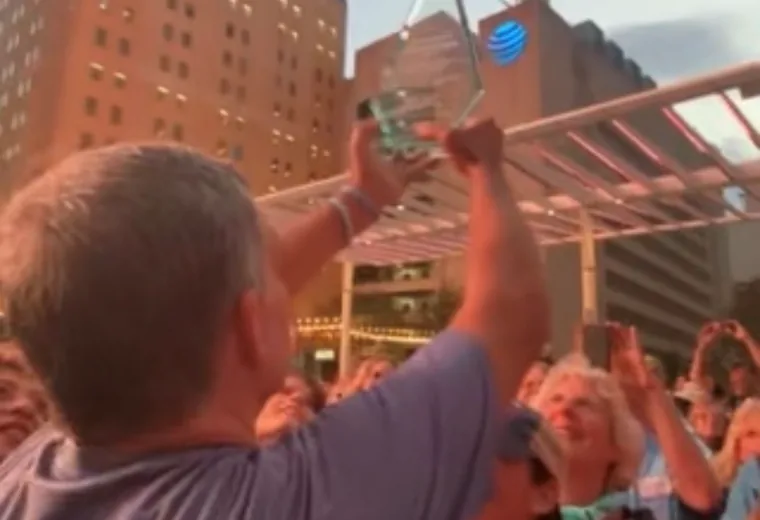 Participant raising an item above an outdoor crowd