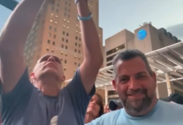 Two participants raising their hands at a city gathering