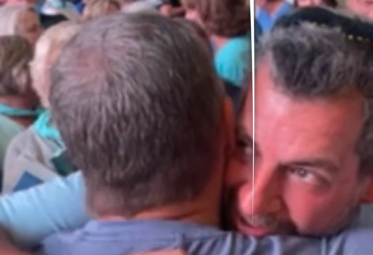 Two people embracing in a crowded gathering