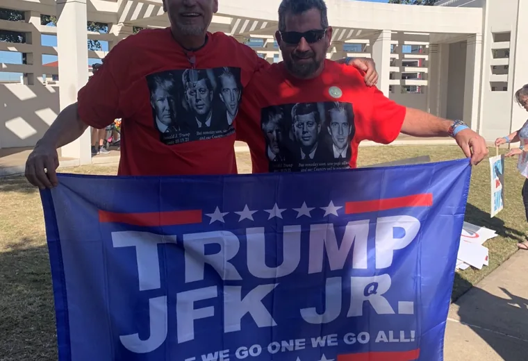Two men holding a large campaign flag