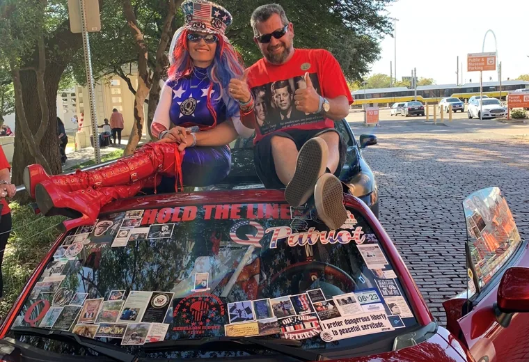 Two people with a decorated red display vehicle
