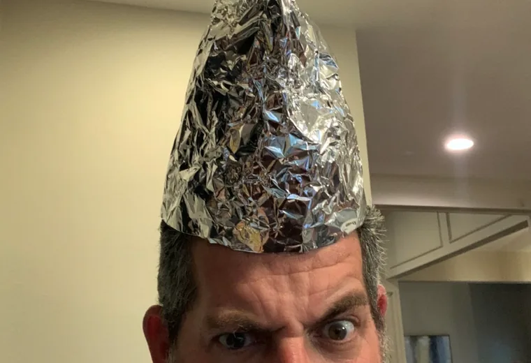 Humorous portrait of a man wearing a foil hat