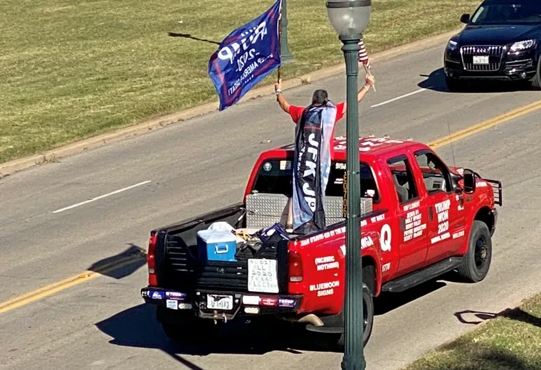 Red pickup truck carrying flags in a procession