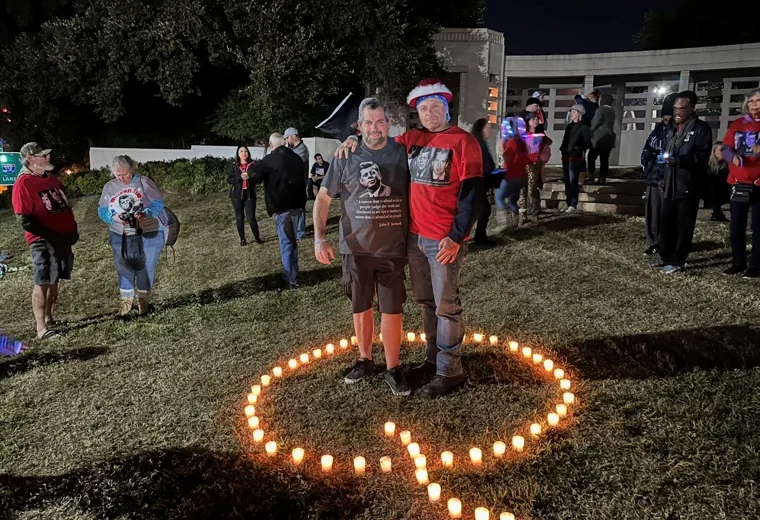 Night gathering around a letter formed from candles
