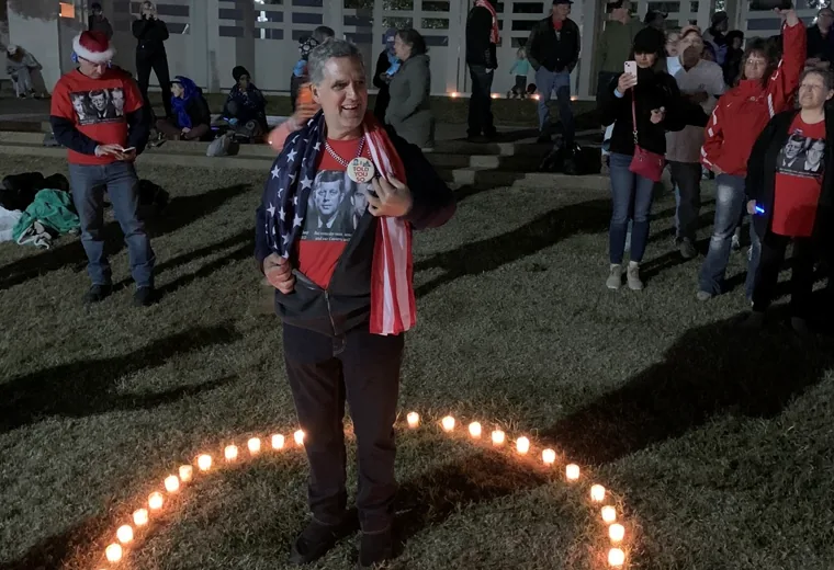 Flag-draped participant standing inside a candle symbol