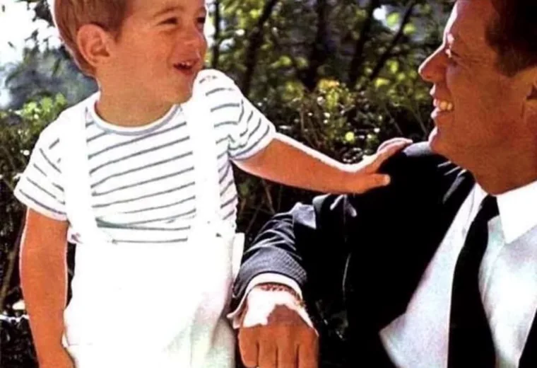 John F. Kennedy smiling with his young son outdoors